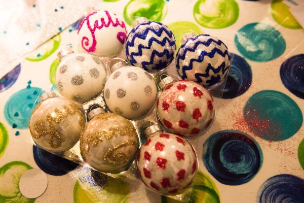 Zelf beschilderde kerstballen met glitterstippen, zigzagmotieven en namen, gemaakt tijdens de workshop kerstballen schilderen